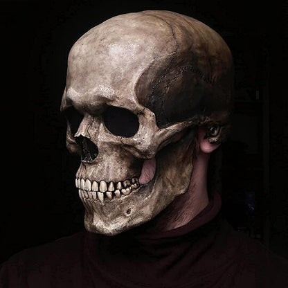 Skull mask worn by a person against a dark background